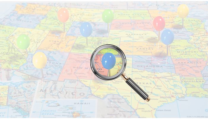 Map with magnifying glass over one pin